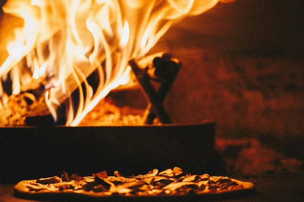 How to Clean a Pizza Oven: The Complete Guide Close-up of wood-fired pizza oven with fire glowing inside