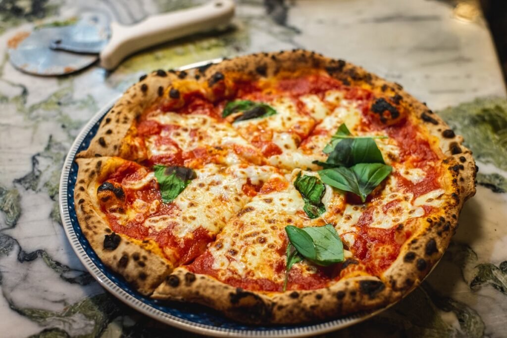 Sourdough Pizza Dough Recipe: 48-Hour Cold Ferment Sourdough pizza dough being stretched with bubbly open crumb structure